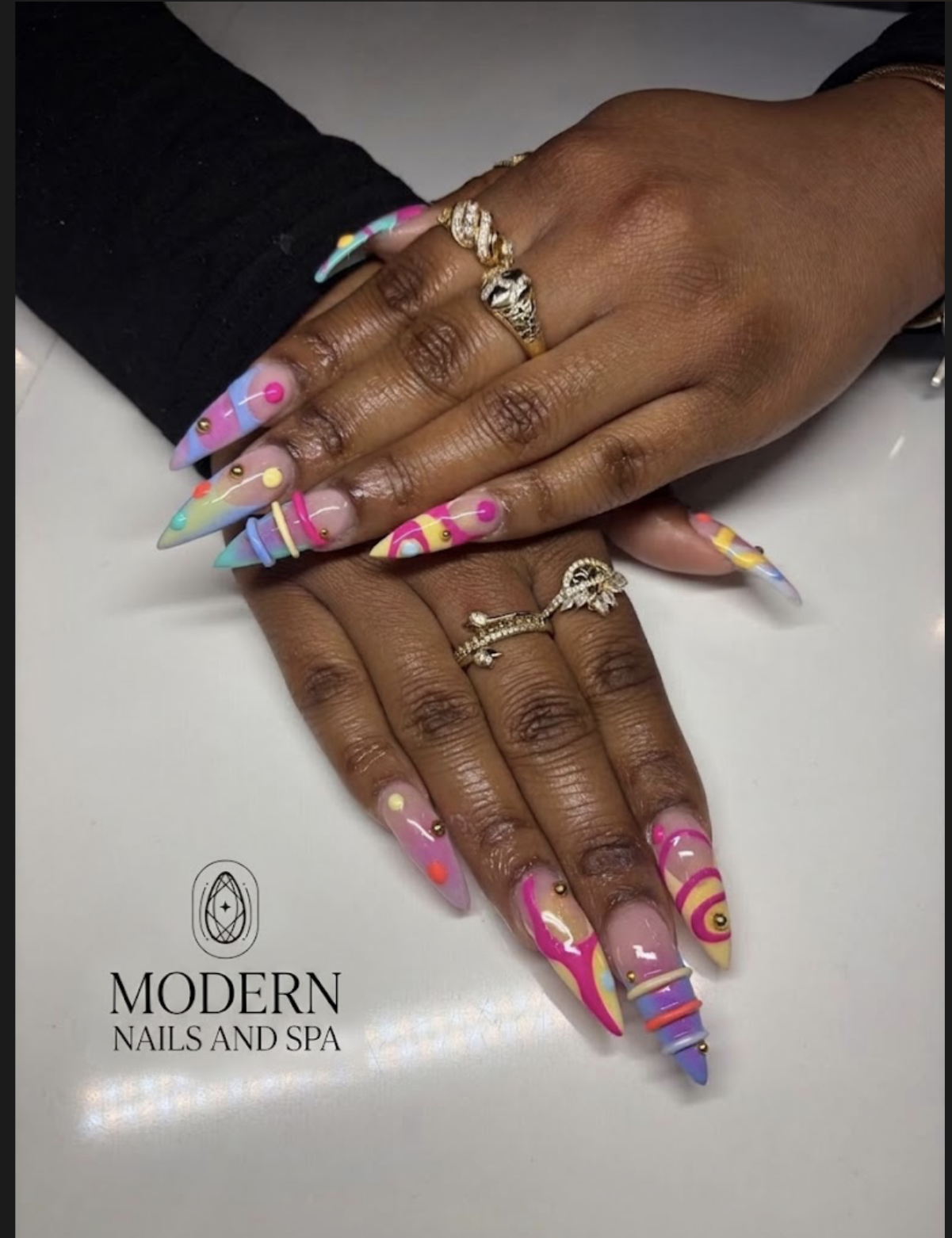 Colorful abstract stiletto nails with gold stud accents